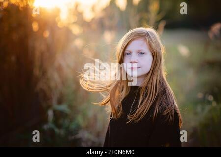 Beautiful young tween girl with red hair in sweater outdoors in fall. Stock Photo