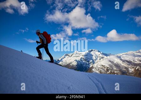 Shilouette of a man ski touring in the Alps, Alpe Devero, Italy.