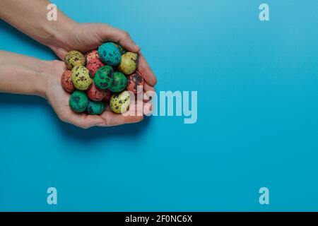 many colored eggs in the palms for easter Stock Photo