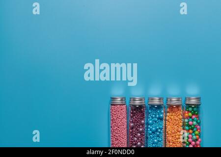 colored balls in glass jars on a blue background Stock Photo
