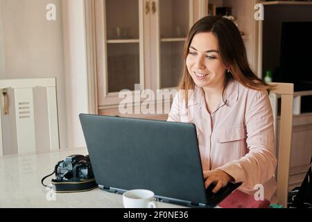 Young woman works from home on her laptop Stock Photo