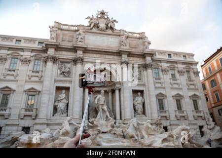 Smart phone on a stick taking picture of Fontana di trevi in Rome, Italy. Selective focus. Stock Photo