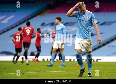 Manchester City's Oleksandr Zinchenko appears dejected as Manchester United's Luke Shaw (hidden) celebrates scoring their side's second goal of the game during the Premier League match at the Etihad Stadium, Manchester. Picture date: Sunday March 7, 2021. Stock Photo