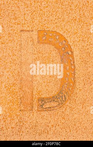Remains of a letter D on a rusted metal plate Stock Photo