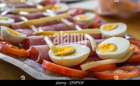 Half boiled eggs, sliced tomatoes, ham and asparagus Stock Photo