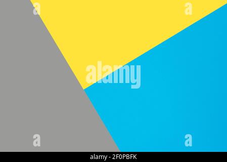 Blue, yellow and gray colored paper. Geometric empty paper background of three tones, copy space. Stock Photo