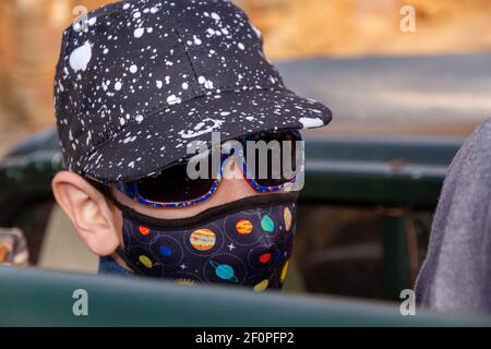 Portrait of a cute boy wearing a cap, face mask and sunglasses Stock Photo