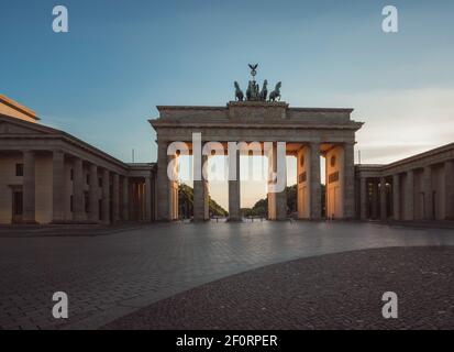 Brandenburg Gate in Berlin, Germany with sunlight shining through during Sunset. Stock Photo