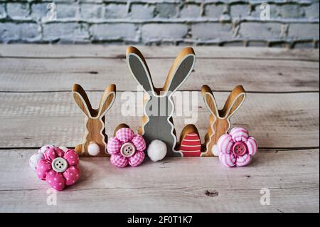 Three wooden Easter bunnies from behind with decoration. Stock Photo