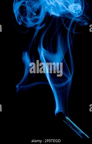 Extinguished match with blue smoke, black background, studio Stock Photo
