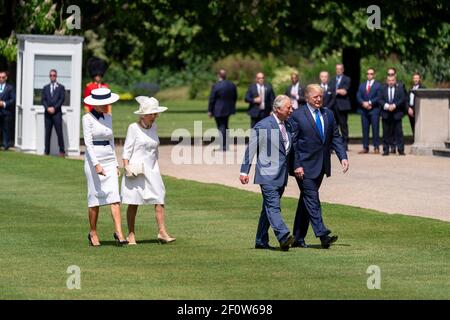 President Donald Trump and First Lady Melania Trump walk across the lawn of Buckingham Palace with Britain's Prince of Wales and the Duchess of CornwallMonday June 3 2019 prior to attending a welcome ceremony in London. Stock Photo