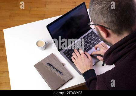 Back view of man working on laptop. Stock Photo