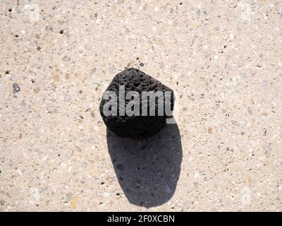 Volcanic stone on concrete surface. Stock Photo
