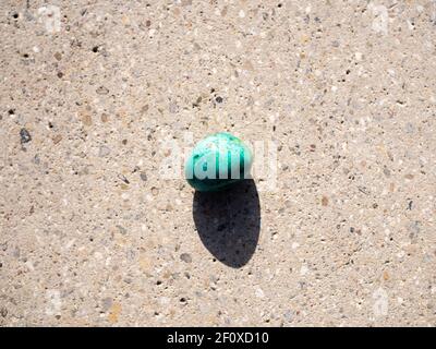 Chrysocolla mineral stone on concrete surface. Stock Photo