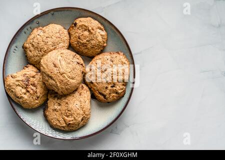 Top view of crunchy oatmeal chip cookies fresh baked biscuits with chocolate and cocoa in a plate on the table homemade food concept with copy space Stock Photo