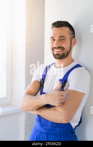 Bearded man in overalls folded his arms over his chest Stock Photo