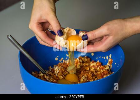 Hand pours out raw egg of the shell Stock Photo