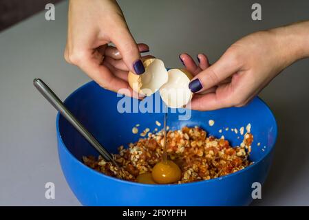 Hand poured down raw egg with shell Stock Photo