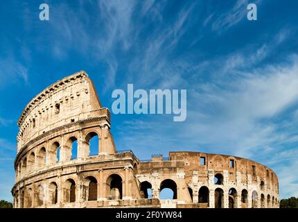 Rome, Italy. Arches archictecture of Colosseum (Colosseo) exterior with blue sky background and clouds. Stock Photo