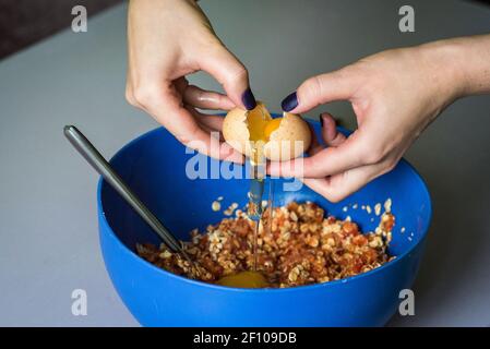 Hand pours out raw egg of the shell Stock Photo