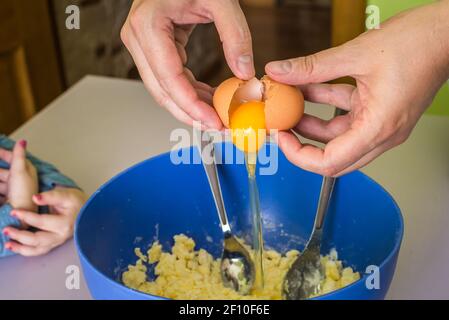 Hand pours out raw egg of the shell Stock Photo