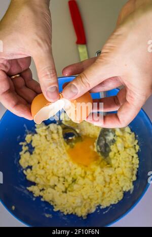 Hand pours out raw egg of the shell Stock Photo