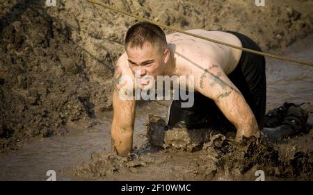 Runners struggle through the mud during the Naval Amphibious Base ...