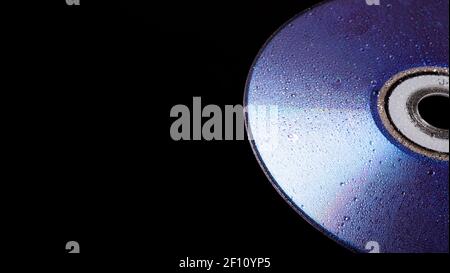 cd disk in the rain. cd drive trash. cd disc. compact disc isolated on black background. Stock Photo