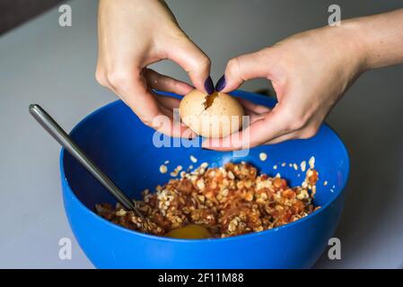 Hand pours out raw egg of the shell Stock Photo