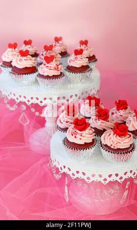 Cupcakes decorated with red roses and hearts for Valentine or weddings Stock Photo