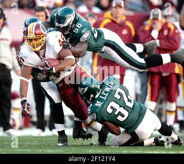 Philadelphia Eagles' Michael Lewis (32) and Ike Reese tackle Carolina  Panthers' DeShaun Foster causing him to fumble the ball in the second  quarter during the NFC championship game Sunday, Jan. 18, 2004