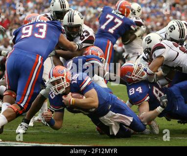 Florida quarterback Tim Tebow crosses the goal line for a touchdown while  being chased by Auburn's David Irons (4), and Will Herring (35) during the  first half of a college football game