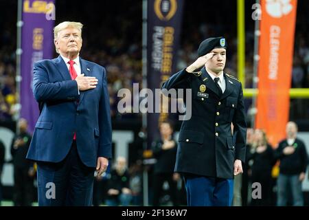 President Donald Trump participates in the National Anthem at the College Football Playoff National Championship Monday Jan. 13 2020 at the Mercedes-Benz Superdome in New Orleans. Stock Photo