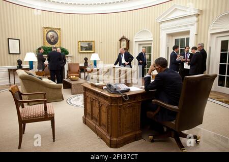 President Barack Obama works on a statement to the press after a phone call with Egyptian President Hosni Mubarak in the Oval Office Jan. 28 2011. Vice President Joe Biden center right and members of the national security team work with the President. Stock Photo