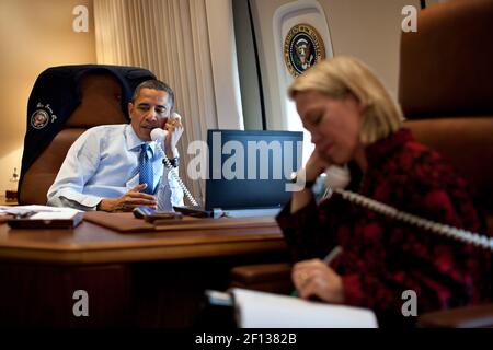 President Barack Obama talks on the phone with President-elect Vladimir Putin of Russia while aboard Air Force One en route to Richmond Va. March 9 2012. Alice Wells Senior Director for Russian Affairs listens in on the call. Stock Photo