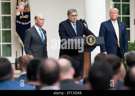 President Donald Trump joined by Secretary of Commerce Wilbur Ross listens as U.S. Attorney General William Barr delivers remarks Thursday July 11 2019 in the Rose Garden of the White House to expand on President Trump's Executive Order requiring every department and agency in the federal government to provide the Department of Commerce with all requested records regarding the number of citizens and non-citizens in the United States. Stock Photo