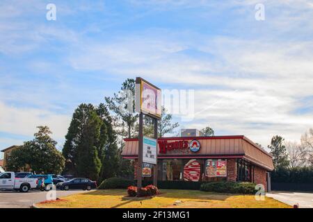 Augusta, Ga USA - 01 06 21: Wendys fast food drive thru restaurant building and street sign and parked cars Stock Photo