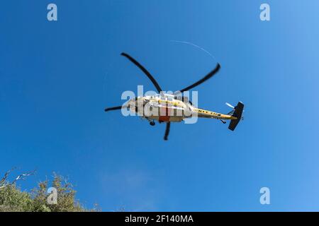 San Gabriel Mountains, California, USA - March 4, 2021:  Los Angeles County fire department helicopter flying low in the Angeles National Forest. Stock Photo