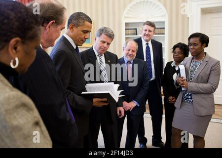 'President Barack Obama receives a leather-bound 2009 edition of the ''Public Papers of the Presidents of the United States'' from David S. Ferriero Archivist of the United States center in the Oval Office Feb. 25 2011. Joining them are staff from the Office of the Federal Register and National Archives and Records Administration.' Stock Photo