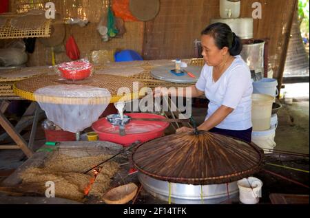 Vietnamese woman making rice paper crepes, Tân Phong Island, Mekong Delta, Vietnam. Stock Photo