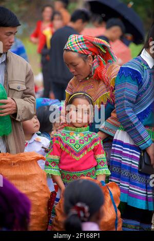Flower Hmong girl in colourful indigenous style attire at market. Bac Ha, Lao Cai province, Vietnam Stock Photo
