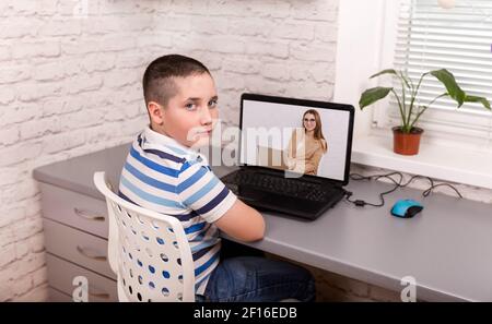 Boy student video conference e-learning with teacher on computer Stock Photo