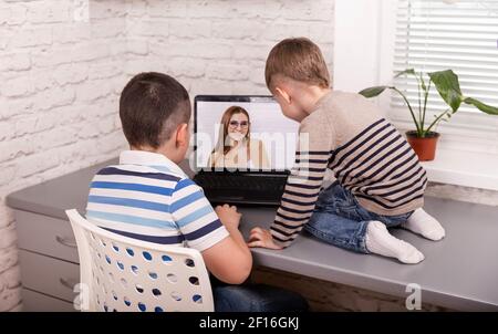 Cute students distance learning on laptop doing homework. Quarantine Stock Photo