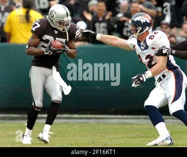 San Diego Chargers running back LaDainian Tomlinson runs away from Oakland  Raiders Fabian Washington (27) and Warren Sapp (99) on a 41-yard touchdown  run during the fourth quarter of an NFL football