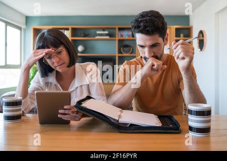 Young couple paying bills on digital tablet. Stock Photo