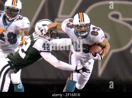 Miami Dolphins wide receiver Wes Welker (83) of the Dolphins tries to slip  the grasp of the New York Jets' Rashad Washington in the fourth quarter.  The Jets defeated the Dolphins, 20-17