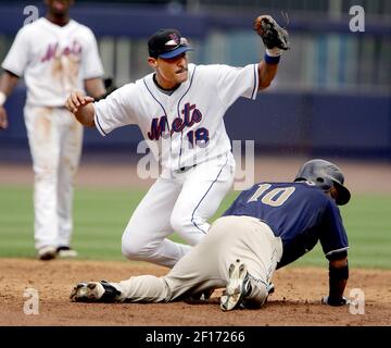 San Diego Padres' Dave Roberts, front, slides safely into second base with  a steal as Colorado Rockies second baseman Jamey Carroll comes in to back  up the play during the first inning