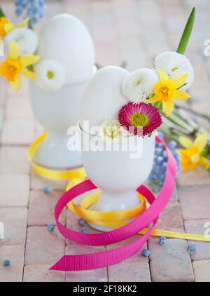 Eggs in egg cups with small flowers Stock Photo
