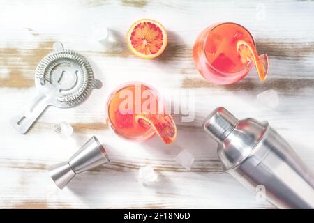 Cocktails, shot from above, toned image. Cocktail glasses, ice and shaker. Atmospheric shot Stock Photo
