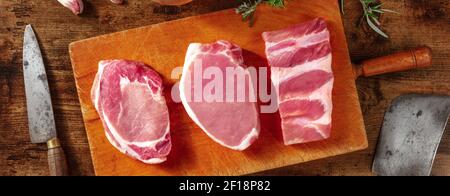 Pork meat panorama on a rustic wooden table, with knives Stock Photo